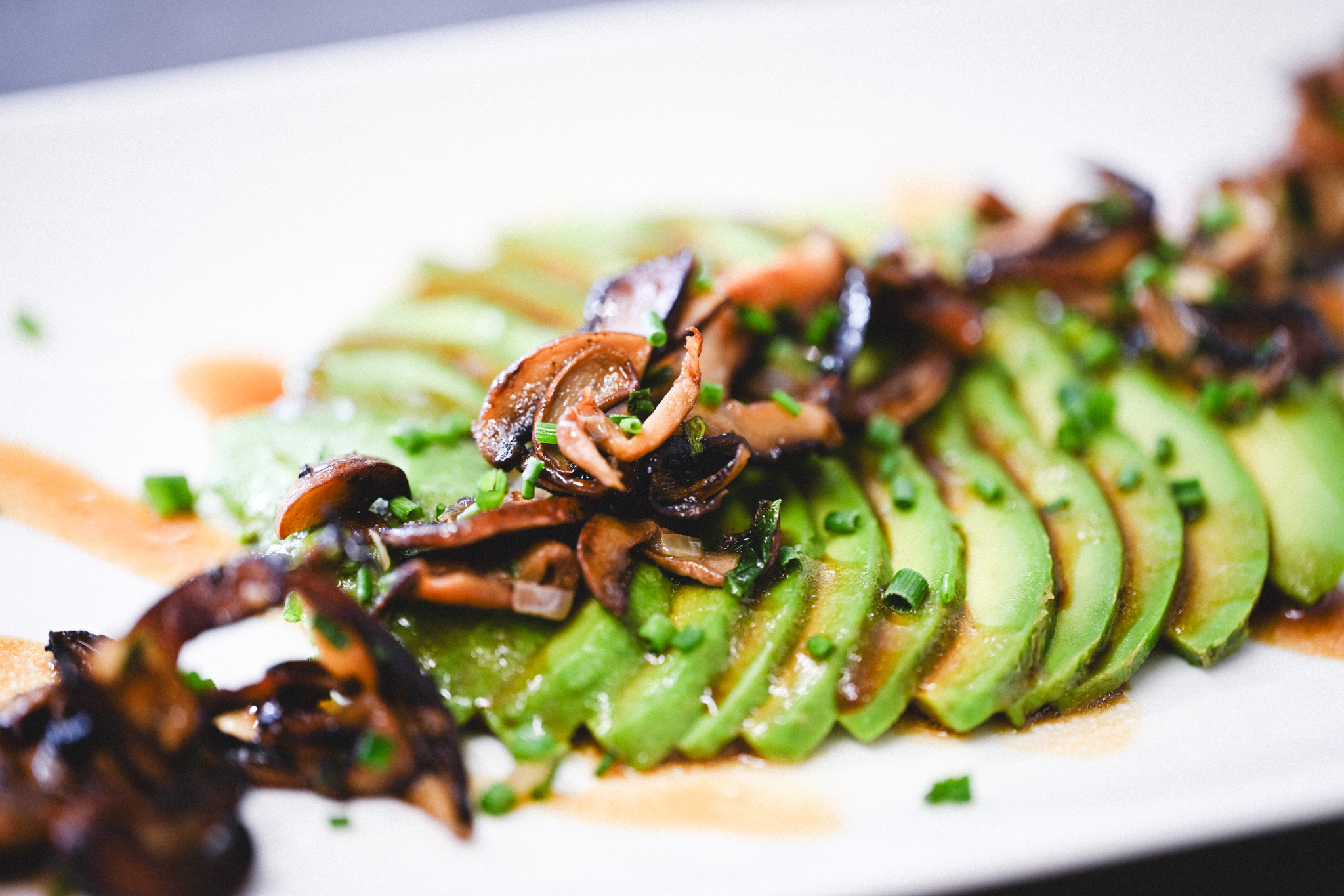 L'avocat en fines tranches, champignons retour de cueillette en persillade et vinaigrette.